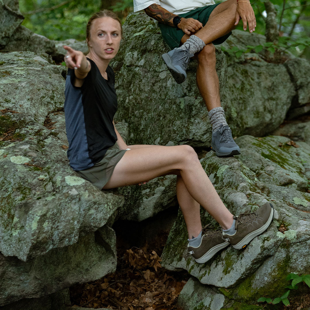 Two people sitting on rocks in a natural setting