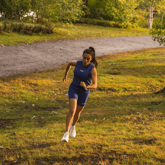 A woman running up a grassy hill